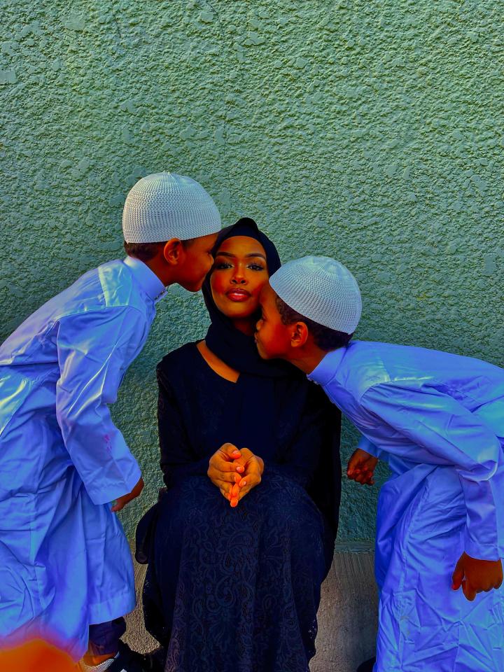 Two kids giving their mother a kiss.