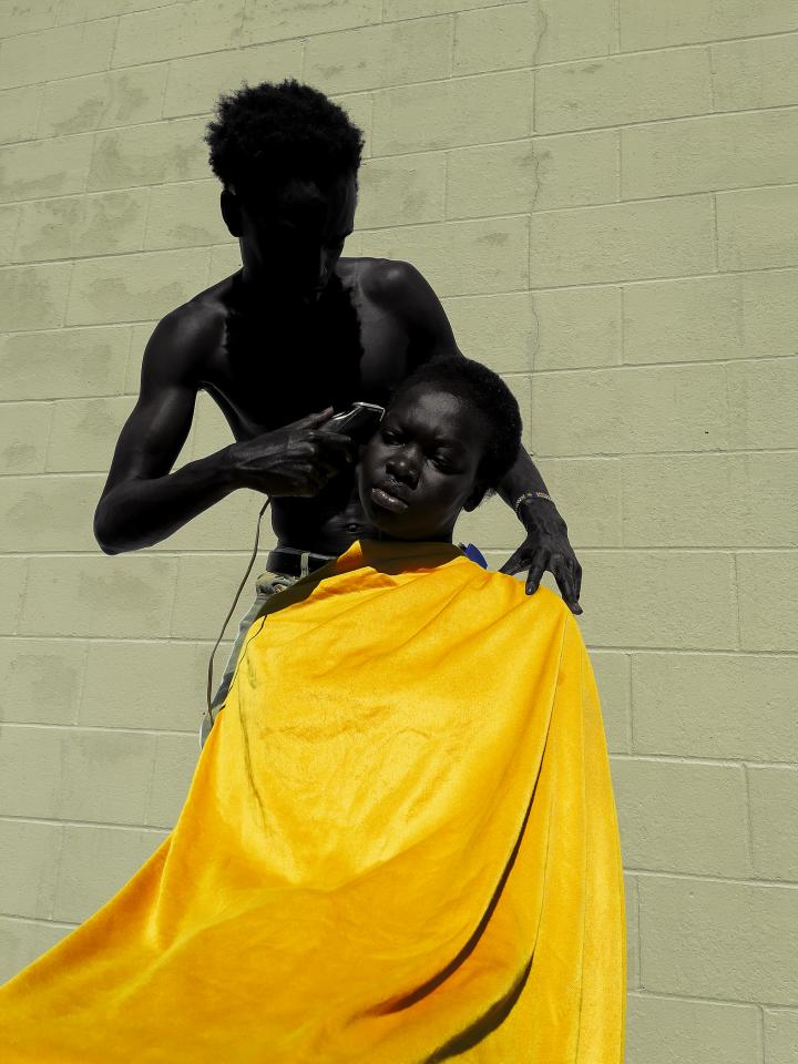 A guy giving a kid a haircut.