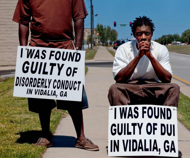 Two men with signs around their necks.