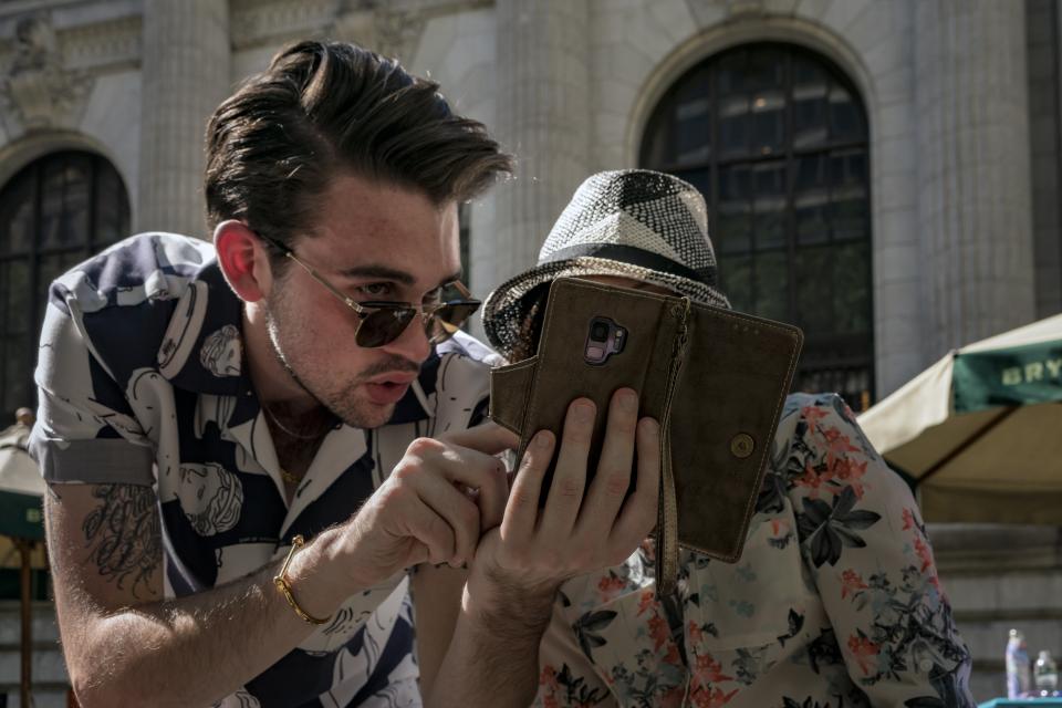 A guy showing his phone to someone.