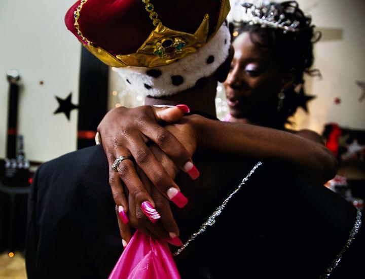 A couple dancing with crowns.