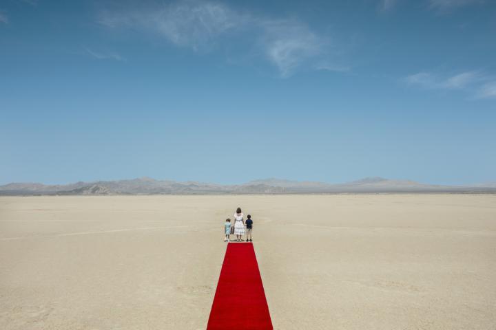 Three kids standing in the dessert.