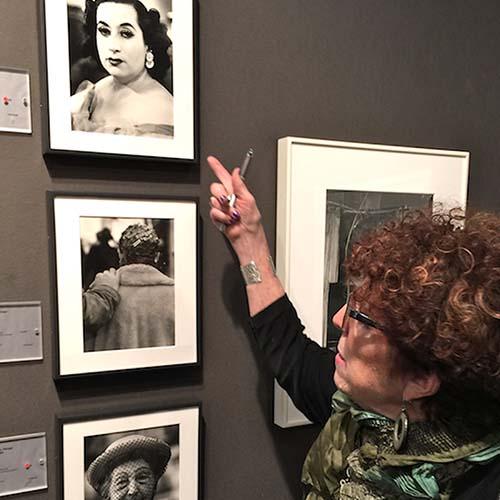 A woman looking at old photos on the wall.