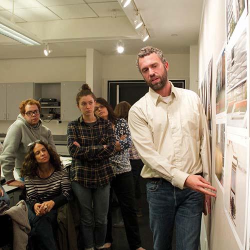 A man presenting in front of a small group.