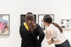 Two people view an exhibition of photography.