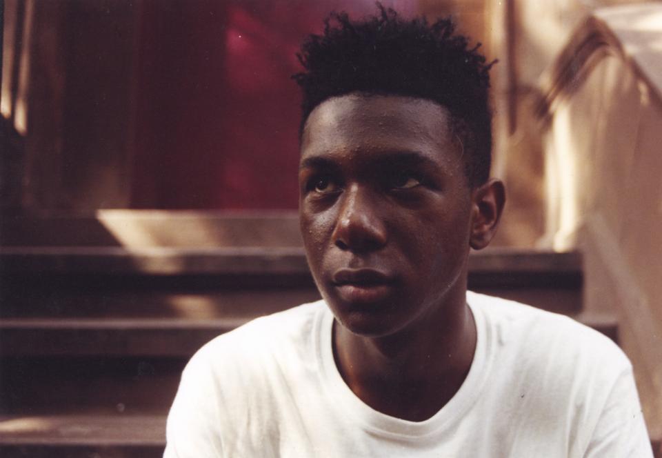 Portrait of a young man sitting on steps in front of a door